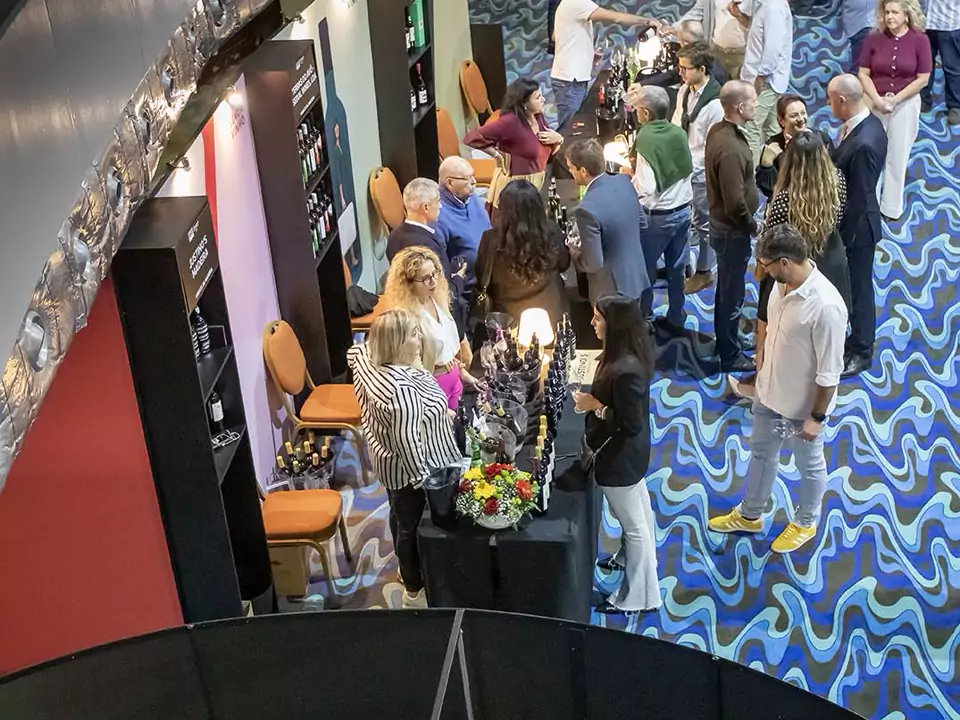 Visitantes a provar vinhos entre os stands do Essência do Vinho Madeira